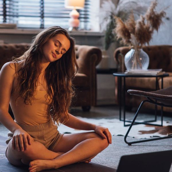 Person stretching gently on a yoga mat with mint color accents.